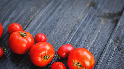 ripe juicy red tomatoes on a black table with copy space