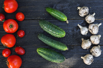 Tomatoes, cucumbers and garlic on the table