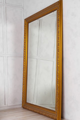 Large classic mirror with golden wooden frame side view, home decor