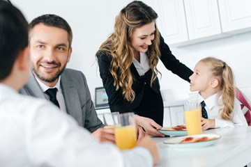 family having breakfast in kitchen at home on first school day