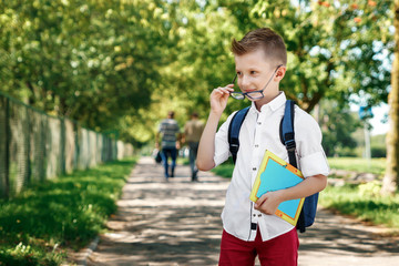 Back to school. A boy from an elementary school with a backpack on the street. The concept of the day of knowledge, September 1, the beginning of school.