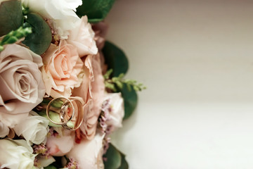 A beautiful picture with wedding rings lies against the background of a bouquet of flowers