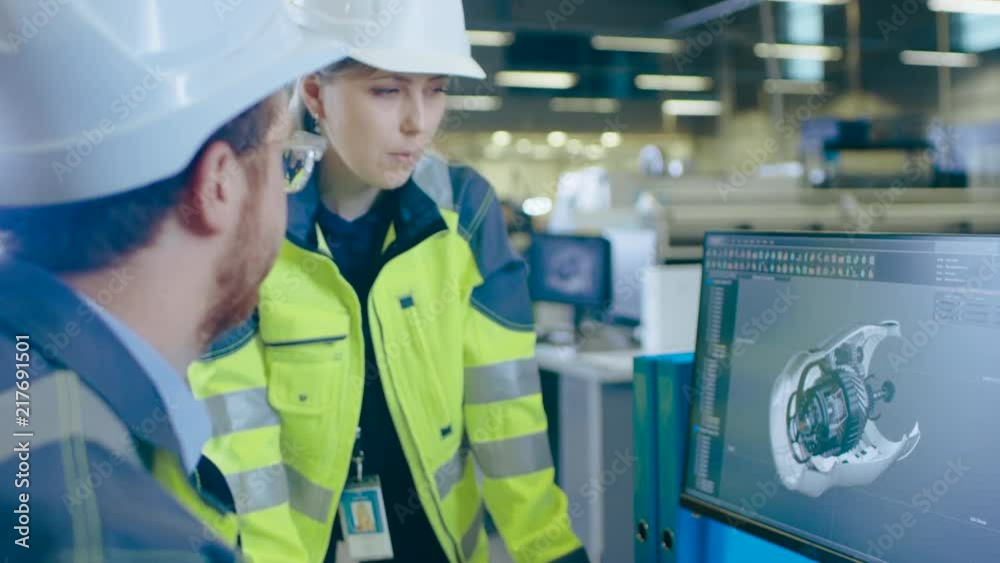 Poster at the factory: male mechanical engineer and female chief engineer work together on the personal com