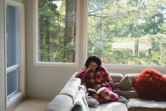 Woman reading a book in living room