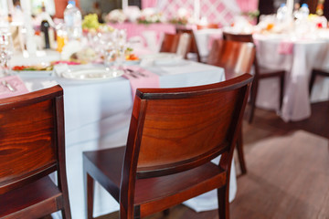 Retro empty vintage style wooden chairs for events and weddings. Brown wooden chair at a holiday or wedding next to a table with snacks