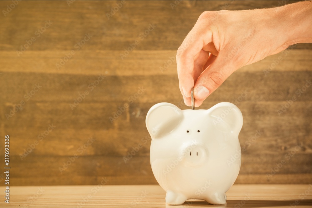 Poster Hand Putting a Coin in Piggy Bank