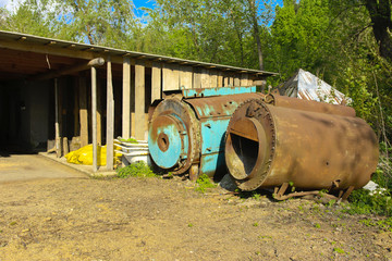 Old abandoned iron rusty tanks and metal structures. The crisis, the collapse of the economy, the cessation of production capacity, led to a collapse. The global catastrophe.
