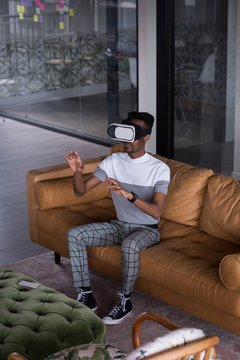 Office executive using Virtual reality headset on sofa