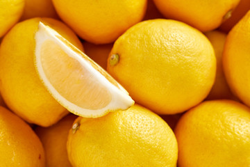 Bunch of fresh lemons in the organic food market. One lemon cutted