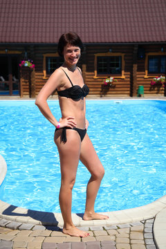 Beautiful mature woman posing for the camera against a turquoise water background. Woman in the pool. Beautiful sexy woman in pool during summer.