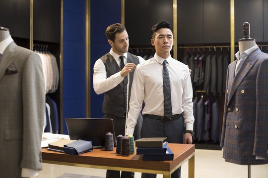 Fashion designer taking measurement of customer