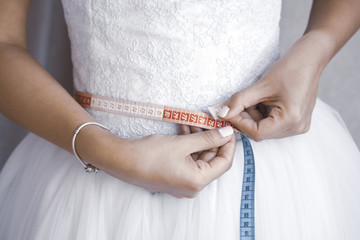 Bride measuring her waist