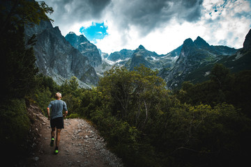 Fototapeta na wymiar Trail runner run in mountains, wild rocks and nature in background