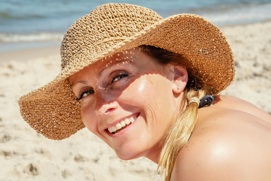 face of a woman in a hat resting by the sea in the summer