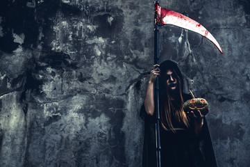 Demon witch with reaper on grunge wall background. Halloween and Religious concept. Demon angel and...