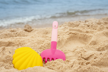 Fototapeta na wymiar colorful mold and rake on the sand on the beach in summer