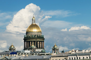 Fototapeta premium Golden dome of St. Isaacs Cathedral in Saint Petersburg, Russia against blue sky and clouds.