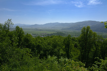 Obraz premium Colorful exalted view from a bird's eye view to houses in residential district in the city of Khust, Western Ukraine with high mountains in the background on a background of green vegetation.