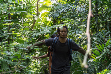male travelers walking through jungle. two man hiking in forest dense. concept of Travel relax, Holiday and vacation.