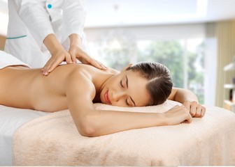 Fototapeta na wymiar Beautiful young woman relaxing with massage at