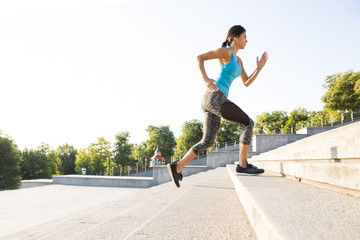 healthy lifestyle sports woman running up on stone stairs sunrise seaside