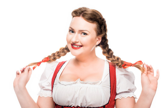 attractive oktoberfest waitress in traditional german dress showing pigtails isolated on white background