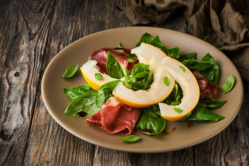 Concept of italian food with melon and prosciutto