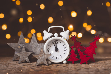 Christmas white alarm clock with vintage red wooden firtrees and brown grey stars with garland...