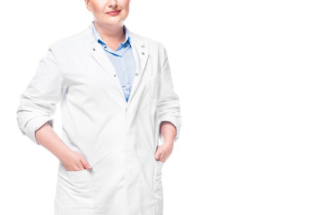 cropped image of female doctor in white coat with hands in pockets isolated on white background