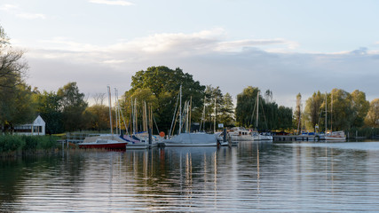 Marina mit Booten an einem See im Abendlicht