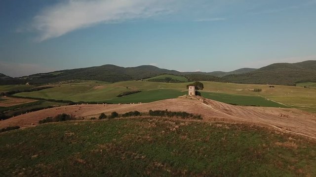 Aerial: Flight over a medieval stone tower near Bibbona, Tuscany, Italy on a lovely summer sunset