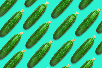 Fresh cucumbers on a colored background, cucumbers with a flower on the end. Pattern of cucumbers. Food background