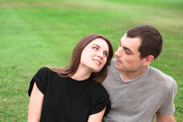 Beautiful couple sit on a blanket on the grass