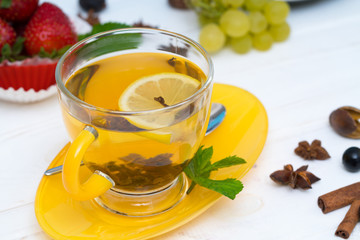 Elegant yellow cup of spiced lemon tea or infusion