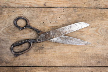 Old rusty scissior on a wooden background