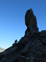 Escalade alpiniste casqué en montagne avec corde et en rappel