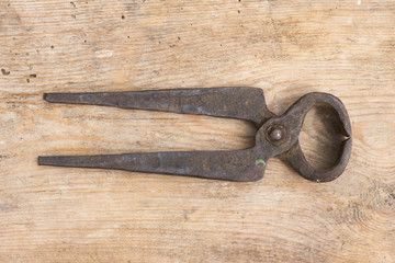 Old rusty  pliers on a wooden background
