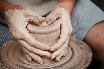 hands of a potter, creating an earthen jar on the circle 