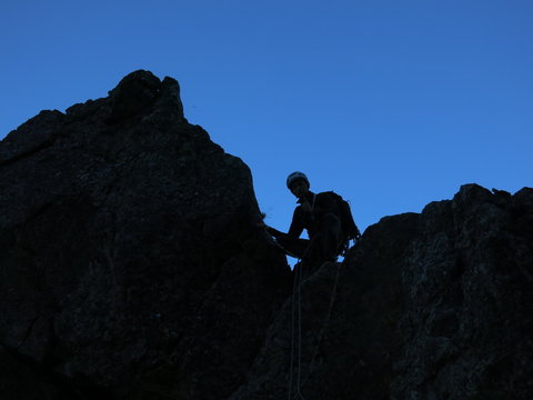 alpiniste casqué en montagne avec corde et en rappel