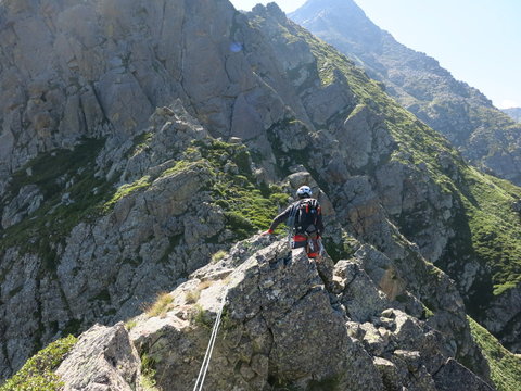 alpiniste casqué en montagne avec corde et en rappel
