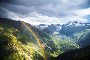 Rainbow in the mountain valley after rain. Grimselpass, Switzerland