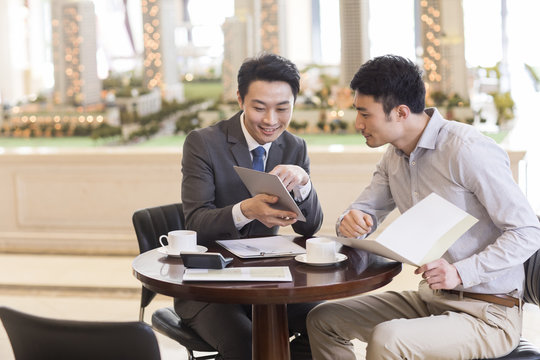 Happy young man buying new house from realtor