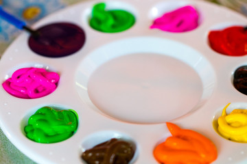 art palette with paint color and paint brushes close-up