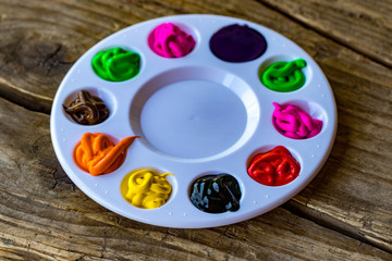  art palette with paints on grey wooden background