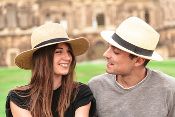 Young fit couple sit together wearing straw hats
