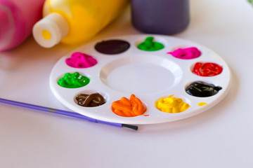  art palette with paints and paintbrush on canvas close-up