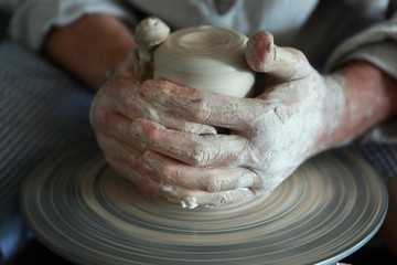 hands of a potter, creating an earthen jar on the circle 