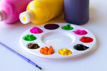  art palette with paints and paintbrush on canvas close-up