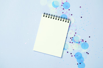 Empty note pad on festive confetti blue backgroung.