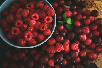 Raspberries and plums on a black table. Berries and fruit. 